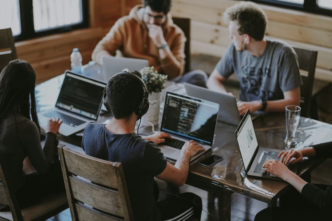 People working on laptops together around a table